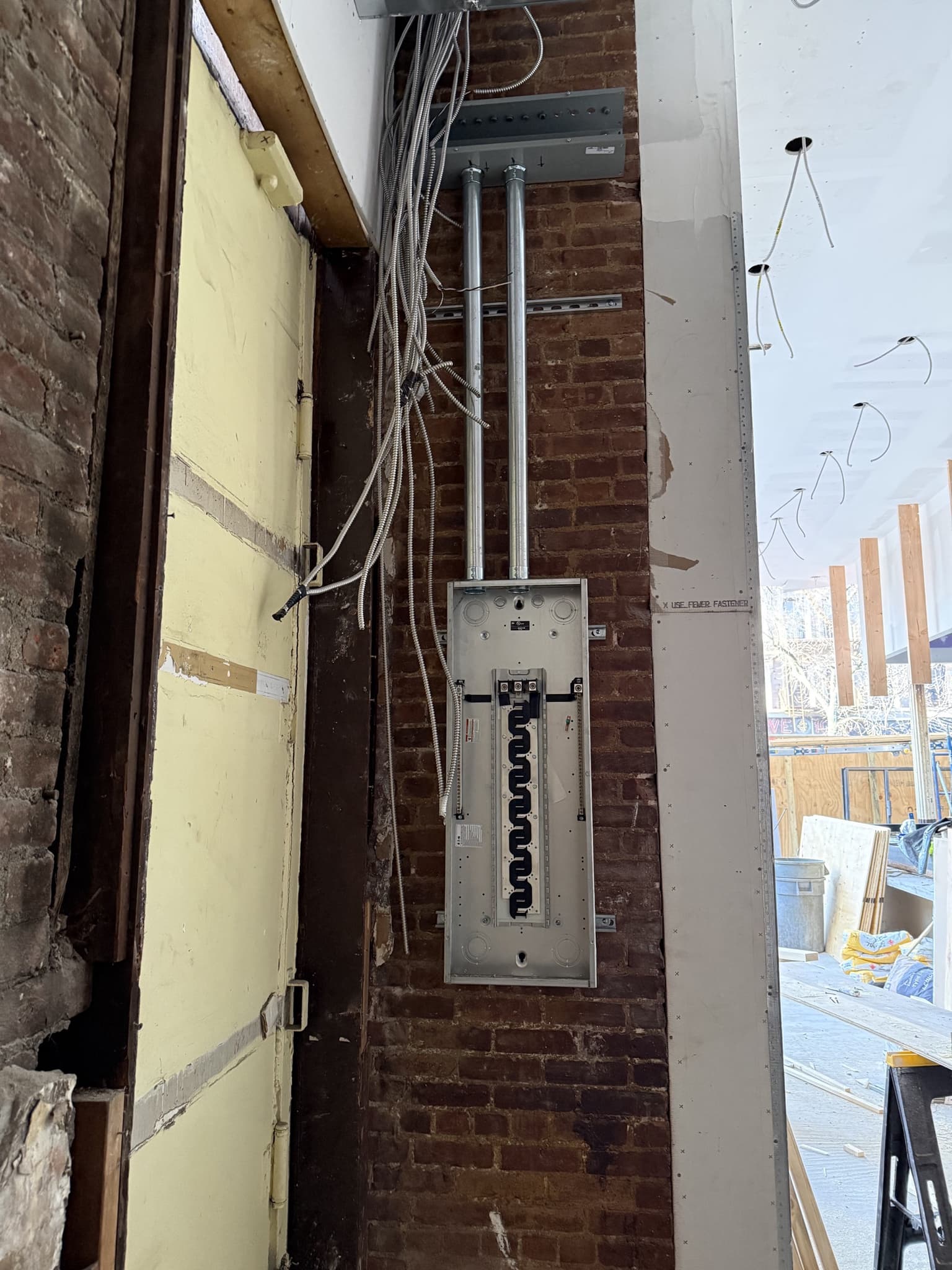 NYC brick townhouse panel rough-in for electrical upgrade with conduit branch routing.