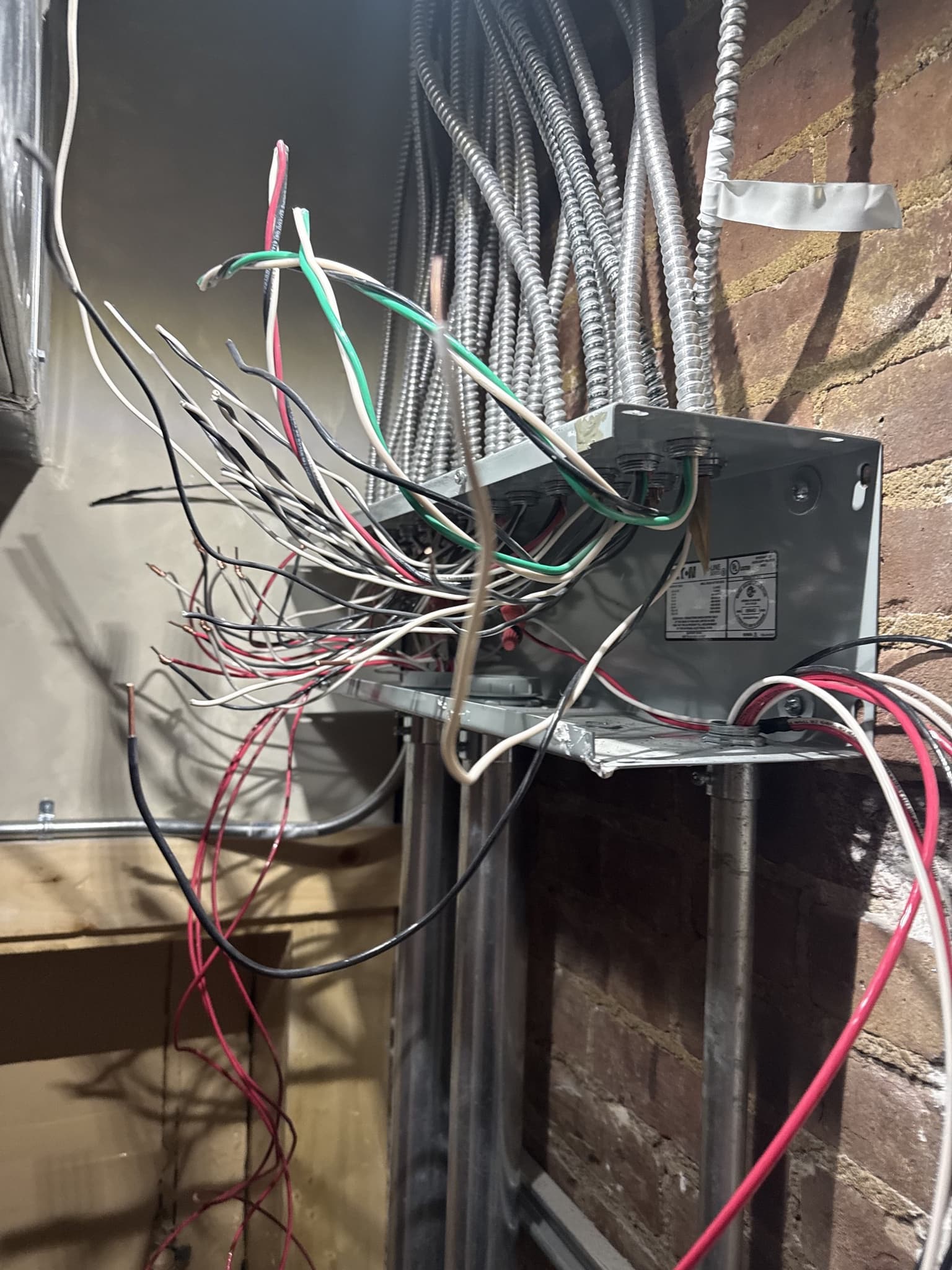 NYC brownstone electrical service disconnect installation on masonry exterior wall.